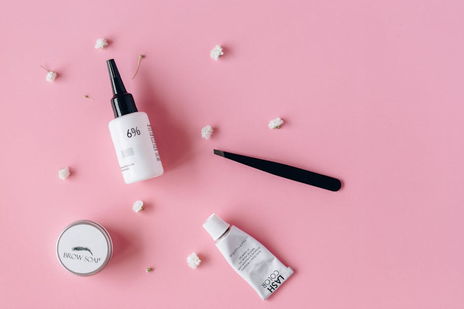 Cosmetic products and tools on a pink background w