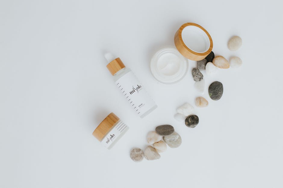 A flat lay of skincare bottles and jars with stone