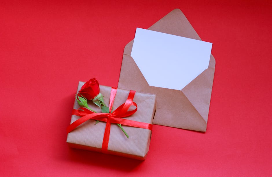 Brown gift box with a red rose and envelope on a v